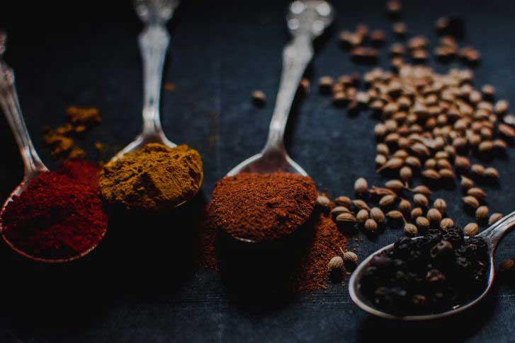 tumeric and other spices shown in spoons