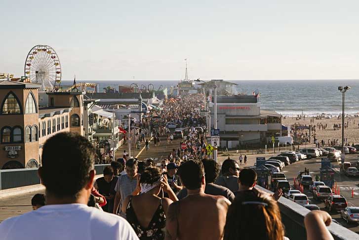 a crowd of people near a lake or ocean during summer who might need sunscreen